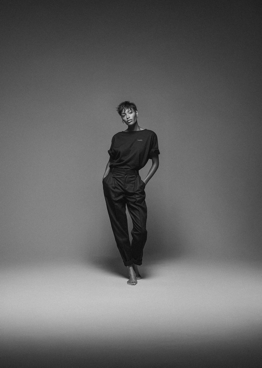 Person wearing a black outfit against a gray background