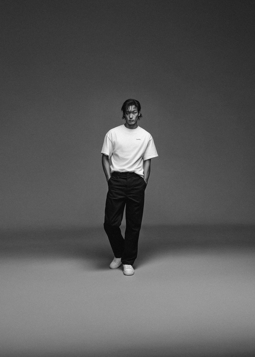 Person wearing a white t-shirt and black pants on a gray background